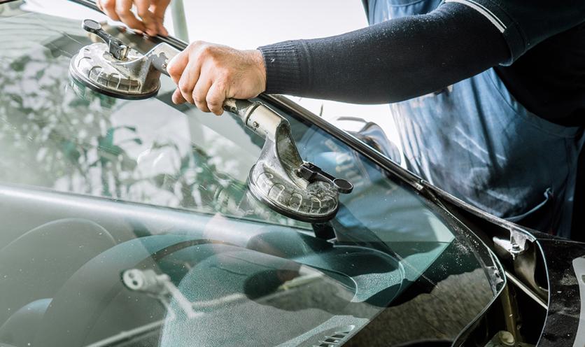 Mechanic replacing car windshield